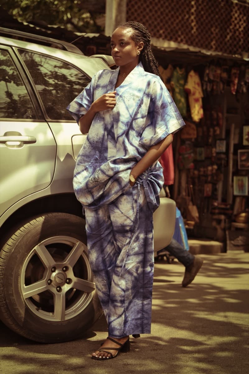 A woman on a street wearing an oversized indigo tie-dye robe with a marbled resist pattern