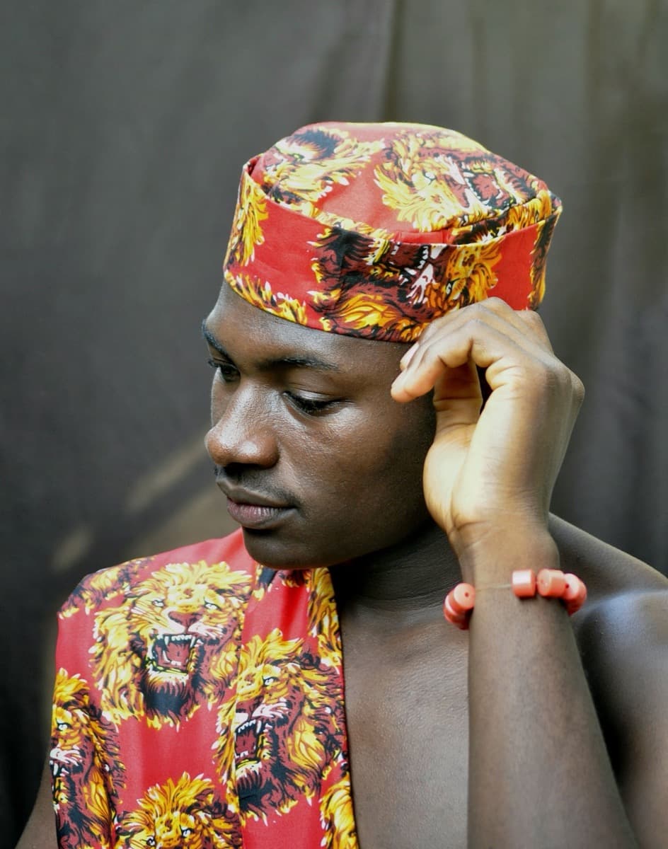 Close-up of the gold animal-head embroidered pattern on dark isiagu fabric